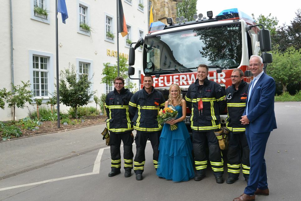 Die Feuerwehrmänner und die künftige Weinkönigin Leonie I. lernen sich nach einem Einsatz vor dem Rathaus kennen. Foto: Presseamt Trier