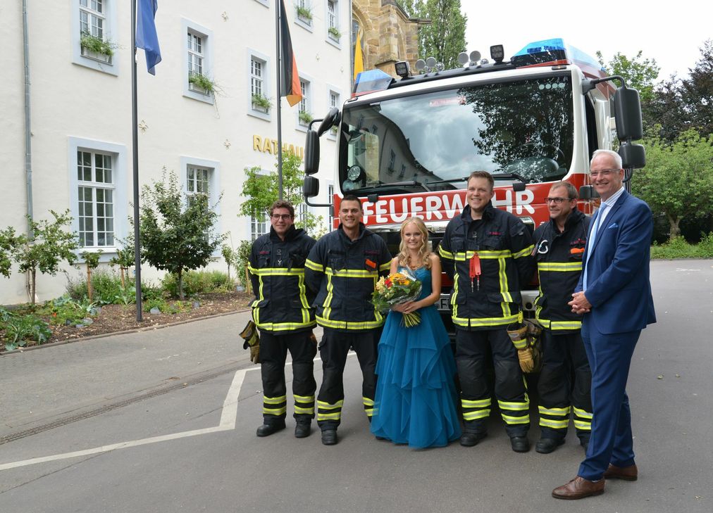 Die Feuerwehrmänner und die künftige Weinkönigin Leonie I. lernen sich nach einem Einsatz vor dem Rathaus kennen. Foto: Presseamt Trier