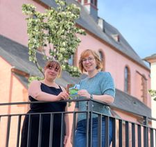 Vor der Markuskirche präsentieren Autorin Jasmin Dietzen (li.) und Illustratorin Katharina Thewalt ihr neues Kinderbuch. Viele Schauplätze und liebevolle Details aus Wittlich finden sich in den Geschichten und Bildern wieder.