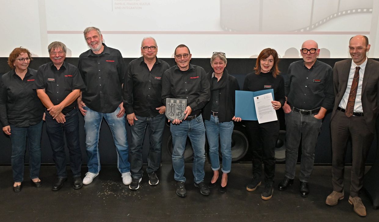 Landrat Volker Boch überreicht das Schieferwappen des Kreises an das Team des Pro-Winzkinos Simmern.