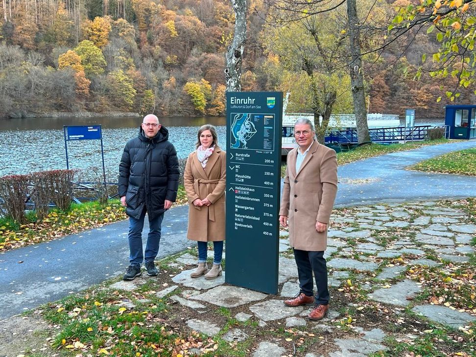 Hochwertig anmutend und informativ führt ein neues Leitsystem durch die touristischen Orte am Rursee: Einruhrs Ortsvoreher Christoph Poschen, die Tourismus-Beauftragte Damaris Schönewald und Bürgermeister Bernd Goffart stellten die neuen Stelen und Fahnenwegweiser vor. Foto: T. Förster