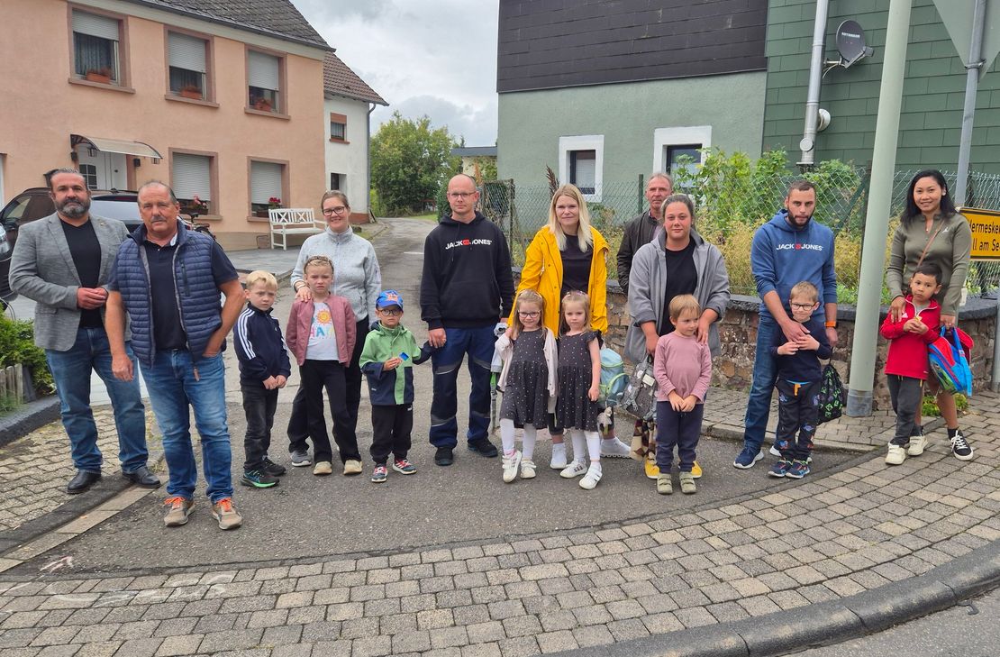 Die Ortsbürgermeister Tim Kohley aus Mandern und Manfred Rauber aus Waldweiler mit besorgten Eltern und ihren Kindern an der gefährlichen Kreuzung mitten in Waldweiler.