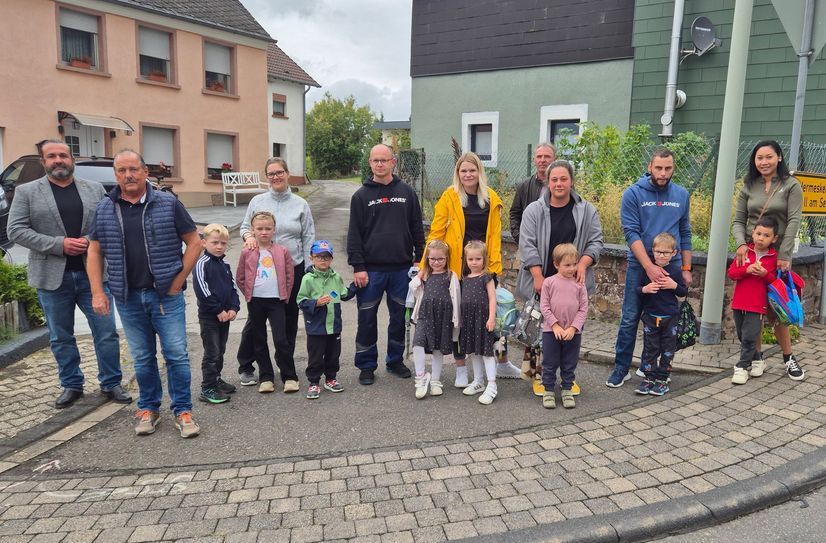 Die Ortsbürgermeister Tim Kohley aus Mandern und Manfred Rauber aus Waldweiler mit besorgten Eltern und ihren Kindern an der gefährlichen Kreuzung mitten in Waldweiler.