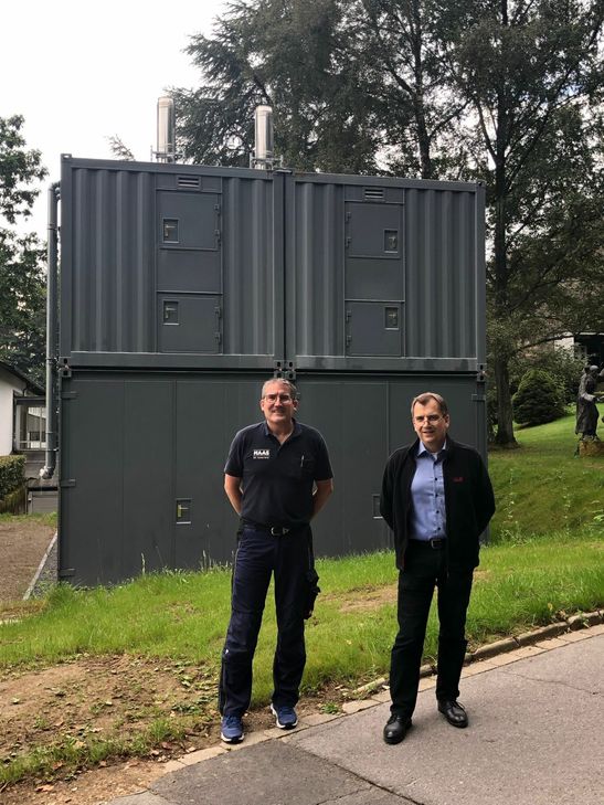 Carsten Henn, Geschäftsführer der Karl Haas GmbH & Co. KG, und Ralf Polis, Geschäftsführer der Franziskus-Stiftung, vor der neue Pelletanlage, die Kloster, Internat und Gymnasium in Vossenack nachhaltig mit Wärme versorgt. Unten sieht man wie es im Innern der Container aussieht. Fotos: Förster / Henn