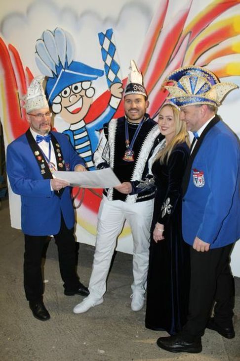Sitzungspräsident Erich Jacoby (l.) und 1. Vorsitzender Jörg Hartig (r.) erklären Prinz Frederik I. und Prinzessin Anna I. das neue Design des Prinzenwagens anhand des Entwurfes. Foto: KV Ruck-Zuck