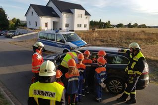 Übung am Pkw: Die Jugendlichen der Jugendfeuerwehr Daleiden mit Betreuerteam, Dany Faymonville (Ehrenamtlicher des DRK) und Norbert Tautges von der Polizei Prüm. Foto: Polizei
