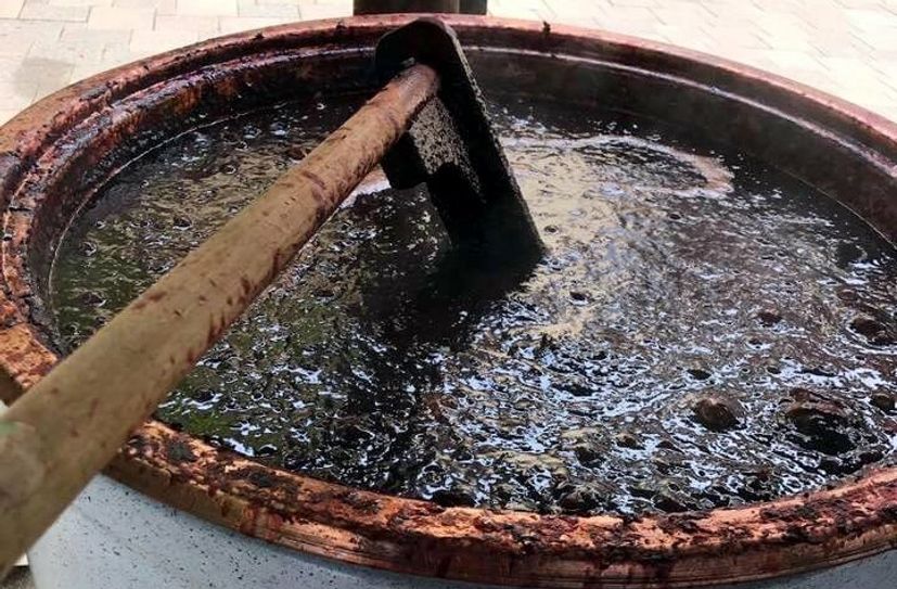 Das Pflaumenmus kocht im großen Kupferkessel.