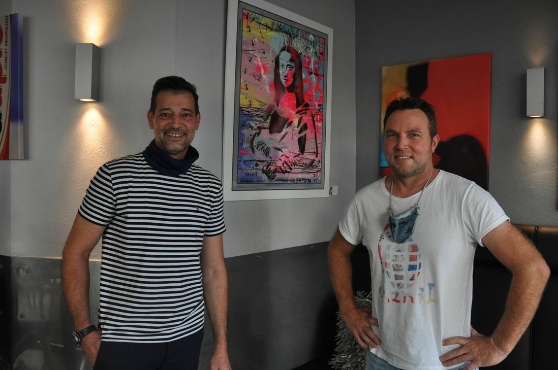 "Dajöh"-Inhaber Stephan Jakobs (links) und Ingo Linz vor einem Exponat des Kolliger Künstlers, das zurzeit im Mayener Café-Bistro zu sehen ist.