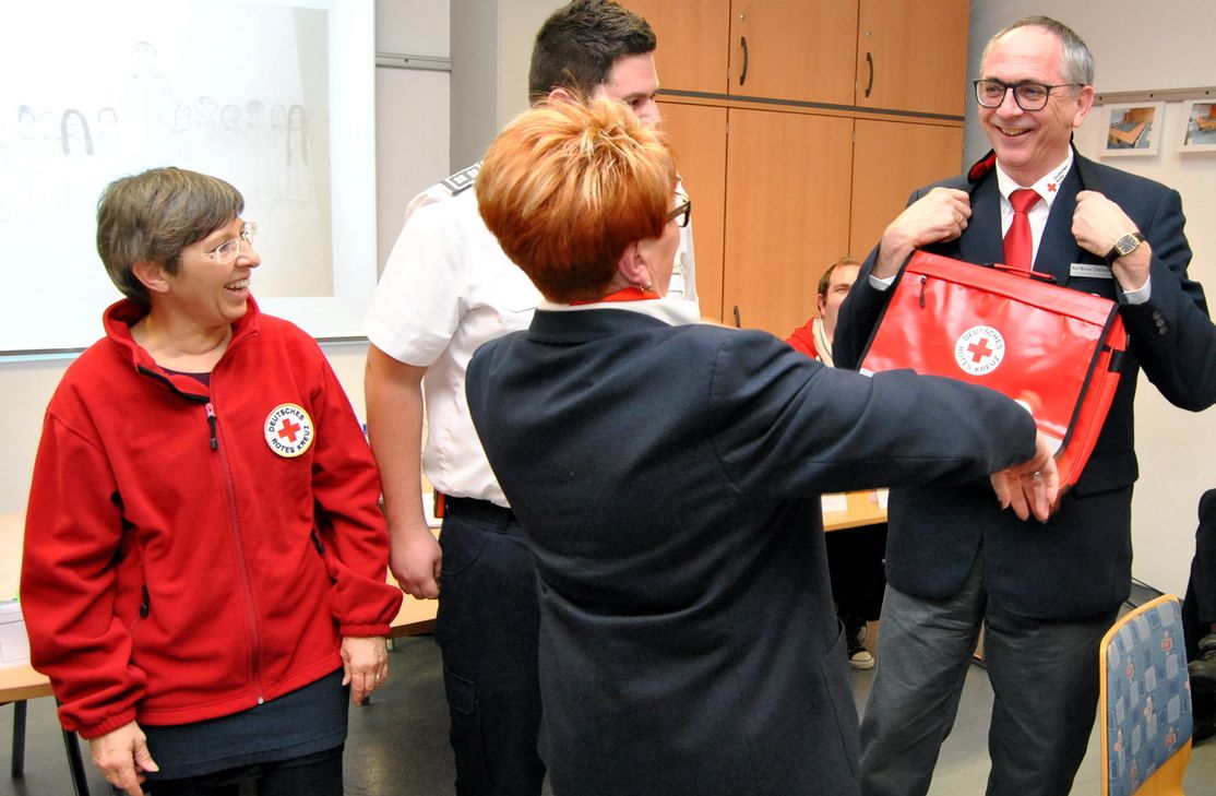 Eine Rotkreuz-Umhängetasche gab es vom Euskirchener Vorstand für den DRK-Kreisvorsitzenden Karl Werner Zimmermann.  Foto: Renate Hotse/pp/Agentur ProfiPress