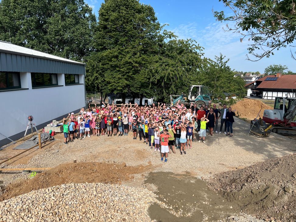 Die Kinder der Gemeinschaftsgrundschule Sistig freuen sich gemeinsam mit der Schulleitung, Gemeindevertretern und Vertretern des Fördervereins auf den neuen Soccer-Court. Die Arbeiten auf der Baustelle sind in vollem Gange.