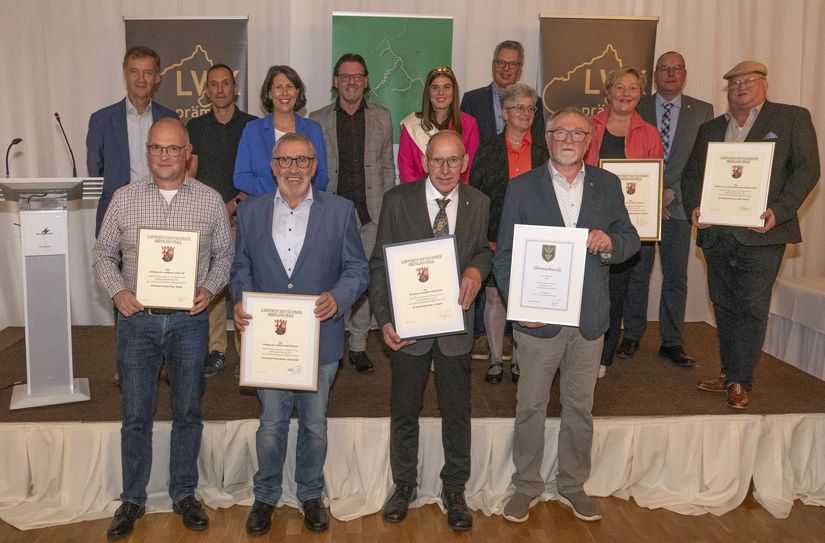 Kammervorstand und Weinbaupräsident Mosel Walter Clüsserath (links) überreichte gemeinsam mit Ministerin Daniela Schmitt (hintere Reihe, 3. von links) die Ehrenpreise des Landes Rheinland-Pfalz an die Erzeugerinnen und Erzeuger.