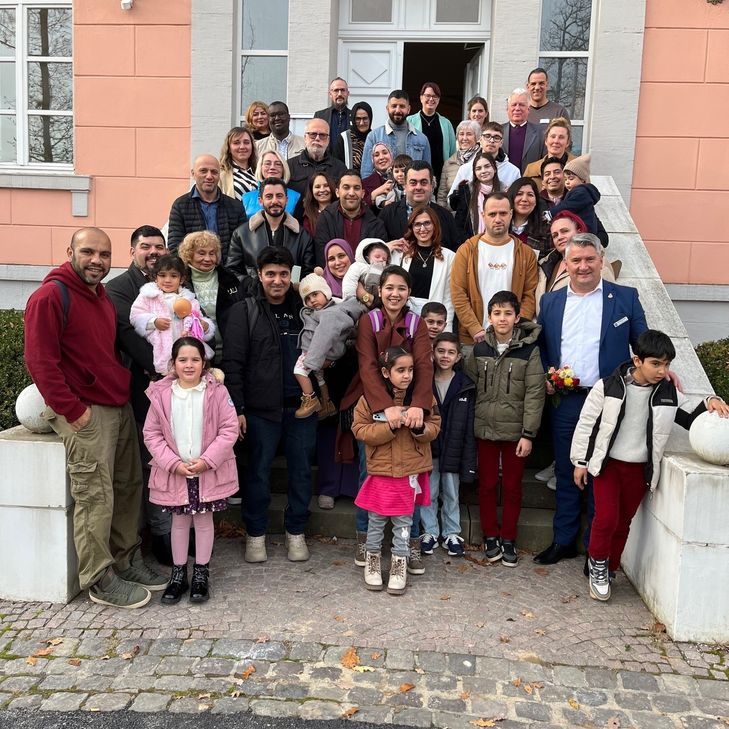 Einen Grund zur Freude gab es am Mittwoch für die Menschen, die sich zusammen mit Landrat Miroslaw Kowalski auf der Treppe vor dem Birkenfelder Schloss aufgestellt hatten. Insgesamt 31 Frauen, Männer und Kinder haben ihre Einbürgerungsurkunde erhalten