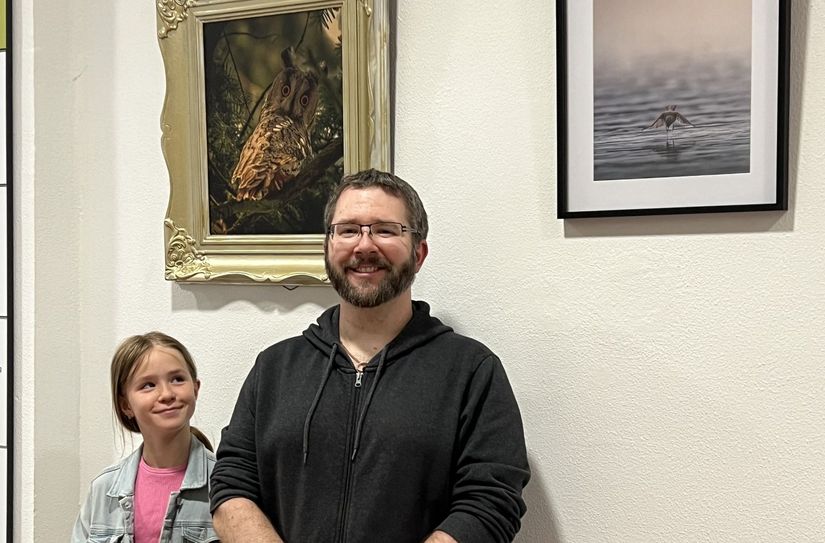 Christopher Norman Schickling mit seiner Tochter Lily Violet im Foyer der Stadtverwaltung vor seinen Bildern