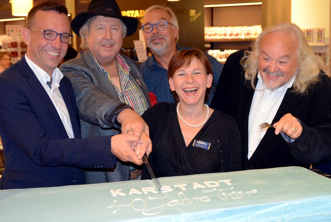 Ende September 2018 feierte Karstadt noch fröhlich das 40 jährige Bestehen seines Warenhauses in der Moselmetropole. Unser Foto zeigt Geschäftsführerin Doreen Jaschinski beim Anschneiden der Geburtstagstorte mit (v.l.) Kulturdezernent Thomas Schmitt, Moderator Heribert Schmitt, Liedermacher Andreas Sittmann und Sänger Helmut Leiendecker. Nur etwas mehr als zwei Jahre später soll die Trierer Filiale der Warenhauskette Galeria Karstadt Kaufhof Ende Oktober schließen. Foto: Archiv/Finkenberg