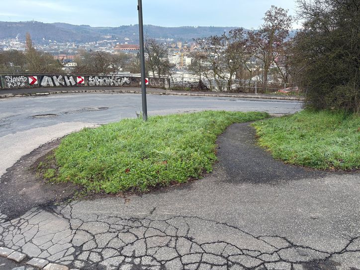 Der Fußweg in der Kurve verläuft künftig innen und wird dort regelkonform ausgebaut, wo heute noch ein Trampelpfad als Abkürzung läuft.