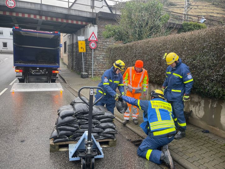 Das THW verschließt gerade mit Sandsäcken die Kanalschächte.