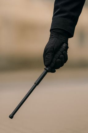 Symbolfoto einer Hand, die einen Teleskopschlagstock hält