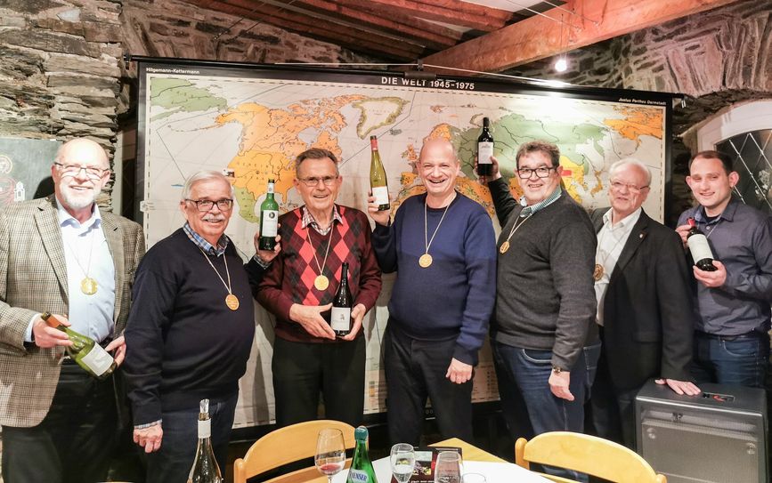 Die Weinbrüder mit ihren Favoriten vor der Weltkarte.