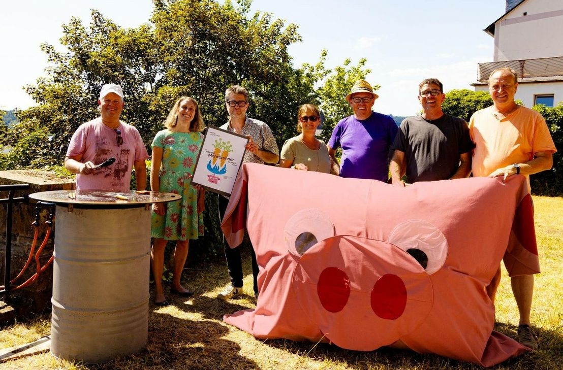 Gimme Muur" ist die Initiative hinter der "kleinsten Möhrbrennerkirmes der Welt" in Wittlich. Hier das Team zusammen mit der Erfinderin der kleinen Biogasgartenanlage Katrin Pütz..