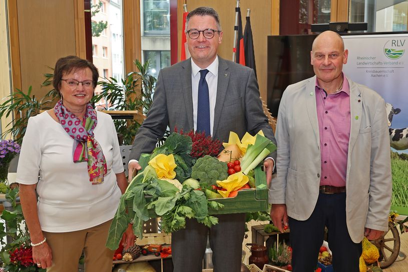 Edith Hamacher (l.), Kreisvorsitzende Aachen im Rheinischen Landfrauenverband und Rolf Funken (r.), stellvertretender Kreislandwirt überreichen Städteregionsrat Dr. Tim Grüttemeier einen Korb mit regionalen Produkten. Foto: Holger Benend