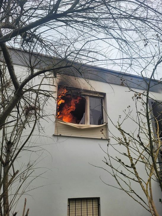 Das Foto zeigt ein Fenster des Bungalows. In dem Raum sind deutlich Flammen zu erkennen. Das Feuer im Bungalow hat sich nach ersten Erkenntnissen in der Küche entwickelt.
