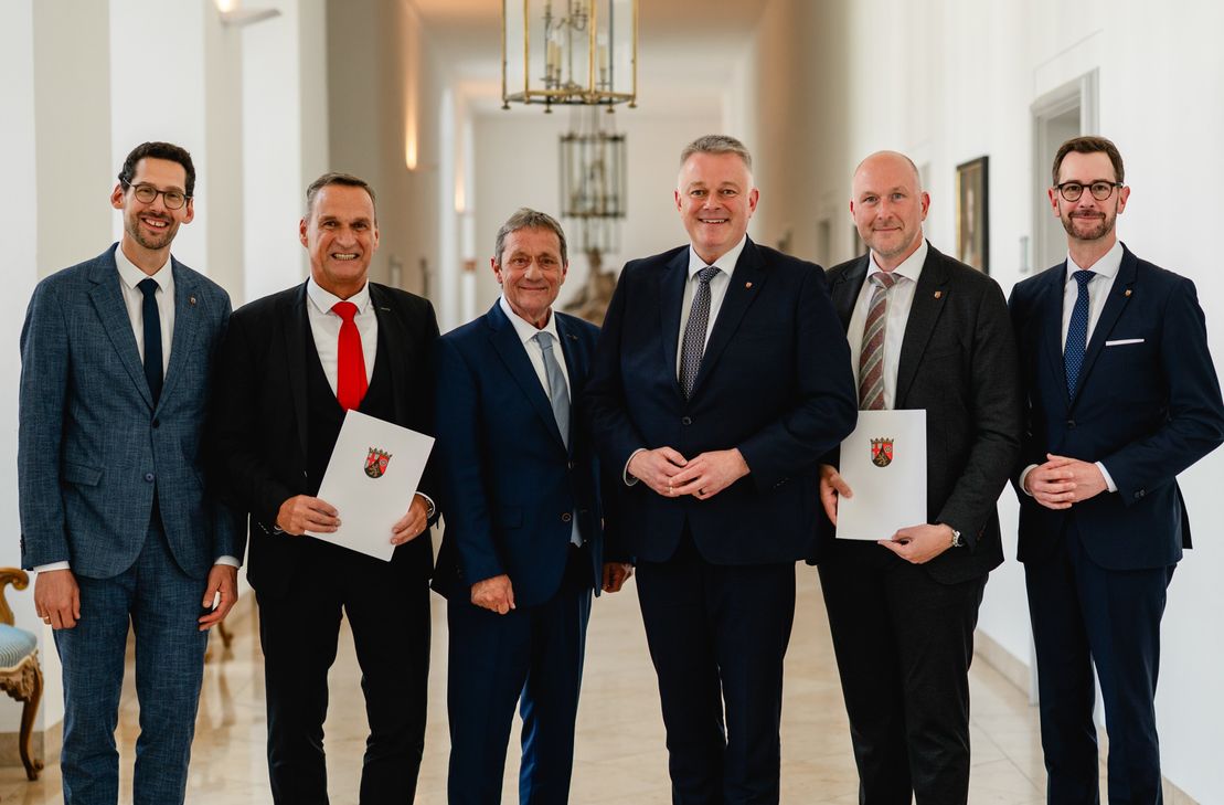 Ministerpräsident Gordon Schnieder (dritter von rechts) mit Innenminister Achim Schwickert (dritter von links), ADD-Präsident Andreas Kruppert (zweiter von rechts) und SGD-Nord-Präsident Joachim Rodenkirch (zweiter von links) sowie die Vizepräsidenten Jens Jenssen (rechts) und Manuel Liguori (links)
