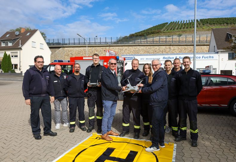 Bürgermeister Guido Orthen (vorne rechts) und Erster Beigeordneter Peter Diewald (vorne links) übergeben der Freiwilligen Feuerwehr Bad Neuenahr-Ahrweiler eine leistungsstarke Drohne für die Löschgruppe Landskrone.