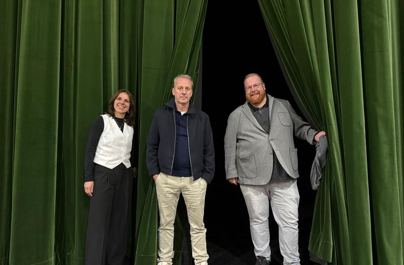 Vorhang auf: Kulturdezernent Markus Nöhl, MVG-Geschäftsführer Arnd Landwehr und Elvira Classen, Leiterin des Amtes für Stadtkultur und Denkmalschutz (v. r. n. l.), stehen vor dem Hauptvorhang auf der Bühne.