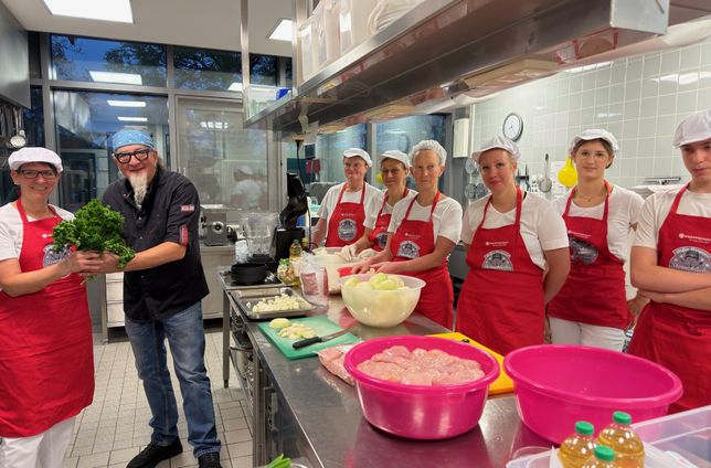 Sternekoch Stefan Marquard (2.v.l.) zeigt dem Küchenteam der Astrid-Lindgren Schule in Prüm, wie man nachhaltig kocht.