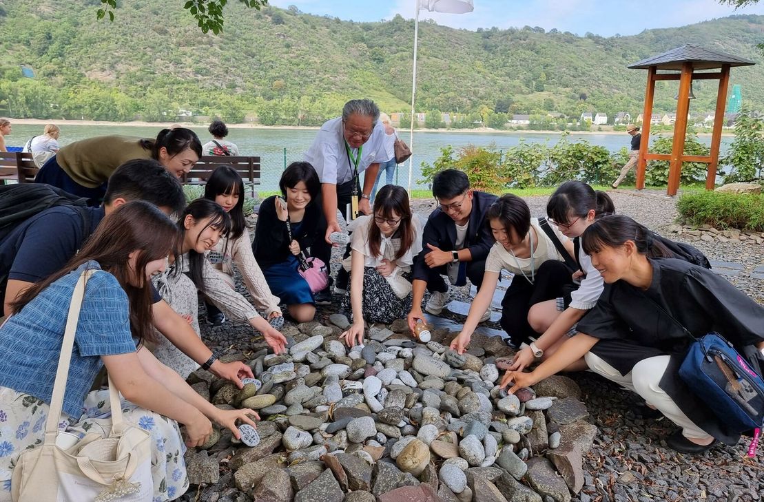 Das Ritual, Steine aus dem Fluss Tama aus Ome in Boppard im Ome-Partnerschaftsgarten auf dem Gelände der Stiftung Bethesda niederzulegen und die Freundschaftsglocke zu läuten, waren ebenfalls wichtige Bestandteile des Austauschs.