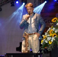 Kurator Janis Kuhnert mit dem Filmpreis "Edgar".