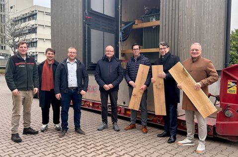 Staatssekretär Michael Hauer, SWT-Vorstand Arndt Müller, Holger Rieth von Holzbau Dawen sowie Mitarbeitende von Landesforsten und SWT vor der neuen Holzstation