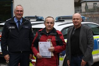 Der mutige Rentner bei der Überreichung der Urkunde durch Polizeichef Heiko Schmitz (links) und Kripo-Ermittler Norbert Flick (rechts).