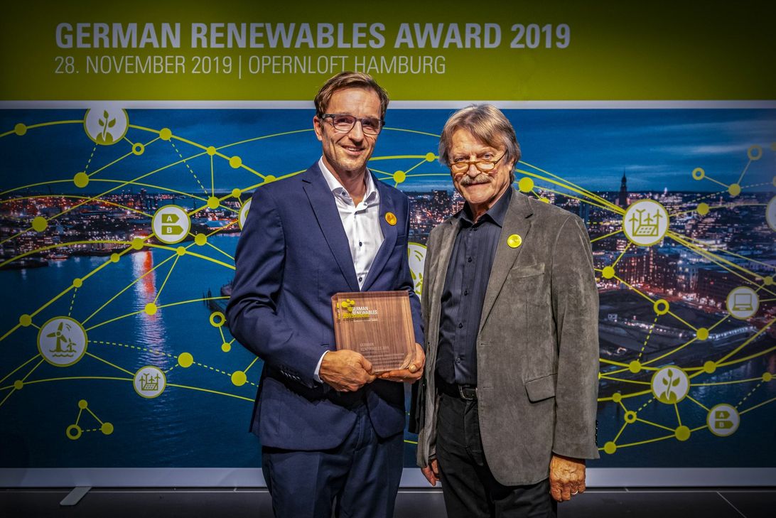 Der SWR-Fernsehjournalist Christian Hattesen erhält aus den Händen des Jurymitgliedes und Laudators Klaus Liedtke den „German Renewable Award 2019“. (Foto: Erneuerbare Energien Hamburg Clusteragentur GmbH)