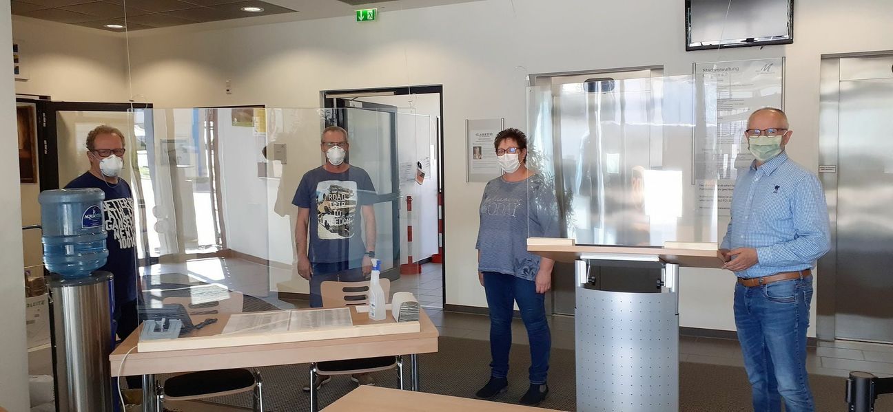 Der gesicherte Eingangsbereich zur Registrierung der Rathausbesucher mit Desinfektionsmöglichkeiten und (von links) den Rathausbediensteten Rainer Schulz, Matthias Kurtensiefen, Sabine Floß und Ralf Claßen. Man betritt das Rathaus von der Bergstraße her, wird auf Einbahnwegen durchs die Verwaltungsflure geführt und verlässt das Gebäude am Schluss wieder durch die Hintertür. Foto: Manfred Lang/pp/Agentur ProfiPress