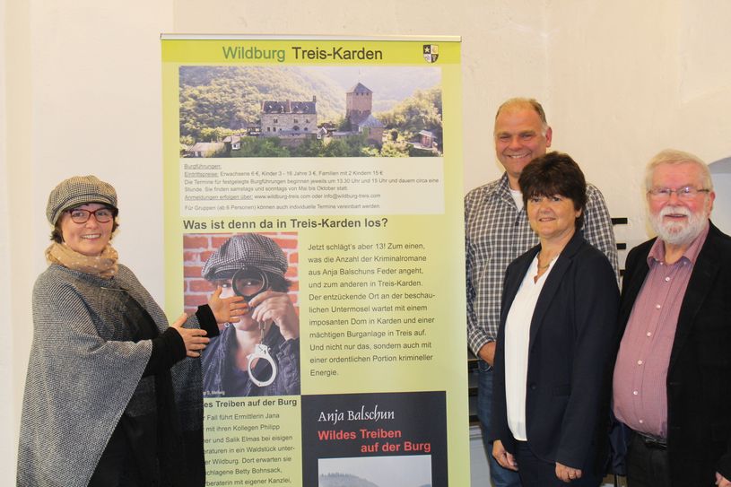 Krimi-Autorin Anja Balschun aus Koblenz im Sherlock-Holmes-Outfit (links) fühlte sich bei ihrer Lesung so richtig wohl unter den vielen Zuhörern im altehrwürdigen Stiftsmuseum. Ortsbürgermeister Hans-Josef Bleser (dritter von rechts) dankte ihr gemeinsam mit seinem Vertreter Jürgen Claßen  (rechts) und Dorotheee Brachtenodrf, Touristik-Information, mit einem "Treiser Burgtrunk", einer Kreation aus Äpfeln aus der Stiftsbrennerei Hambrech.
