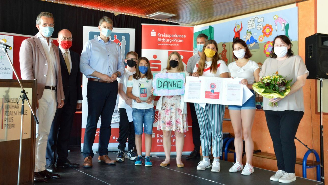 v.l.n.r.: Landrat  Joachim Streit, Ingolf Bermes Vorsitzender des Vorstandes der Kreissparkasse Bitburg-Prüm, MdB Patrick Schnieder, zusammen mit den Schülern der AG, sowie Schulleiter Stephan Schilling und Brigitte Richter-Weber, Leiterin der AG. Foto KSK