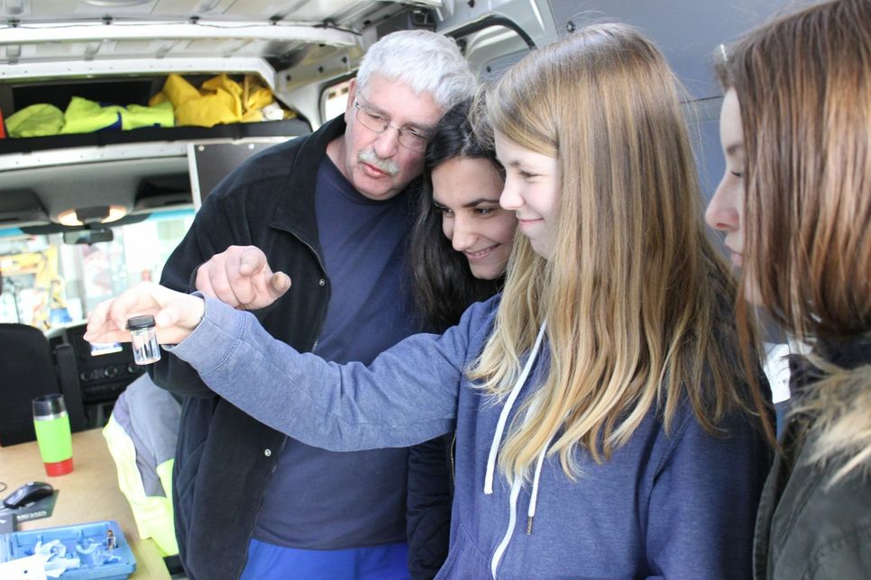 e-regio-Mitarbeiter Winfried König analysiert beim Girls‘ Day gemeinsam mit den Schülerinnen eine Wasserprobe im mobilen Labor.