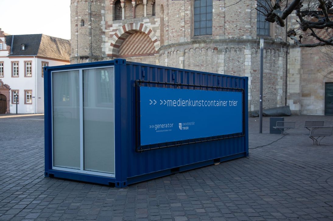 Der ""medienkunstcontainer trier ist ein innovativer mobiler Raum für Medienkunst mit leuchtender Installation, die nur bei Dunkelheit zu sehen ist.