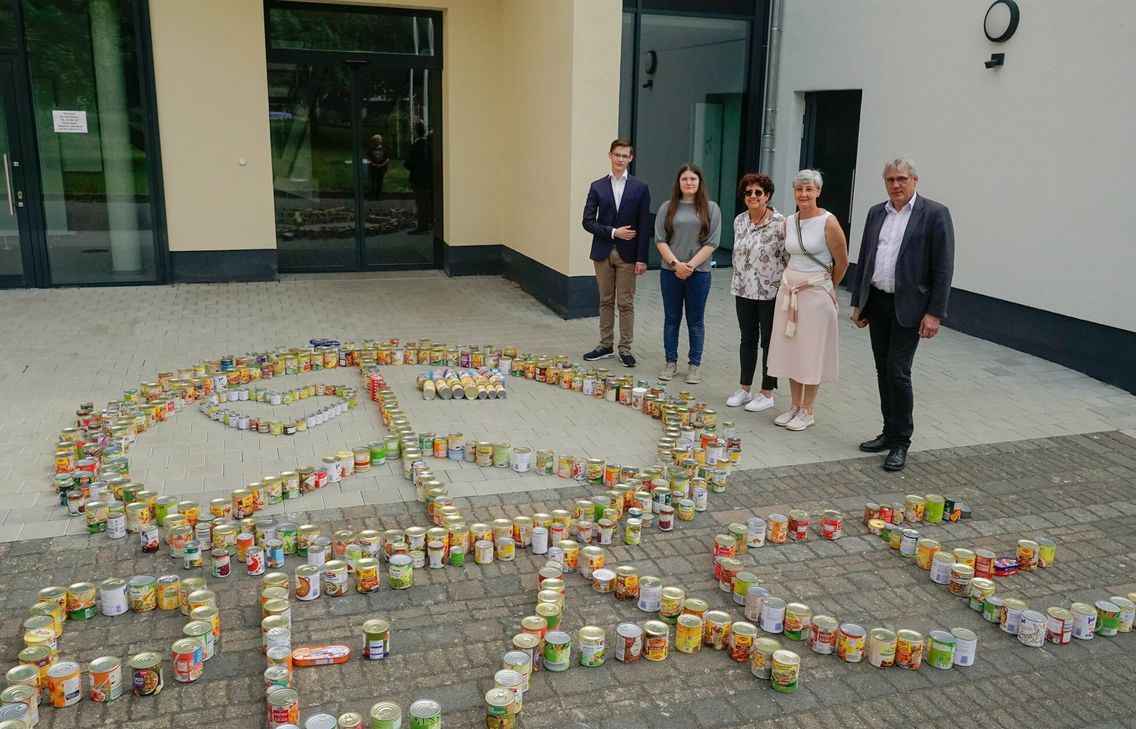 Von rechts: Malte Möbius, Schulleiter der IGS Maifeld, Rita Flöck, Flüchtlingshilfe e.V. Polch, Claudia Sauer, Impulsgeberin der »Glücksritter-Aktion«, freuen sich mit den Schülersprechernüber die erfolgreiche »Konserven«-Aktion.
