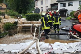 Die braunen Wassermassen bahnen sich ihren Weg durch Hüttingen an der Kyll. Foto: Agentur Siko