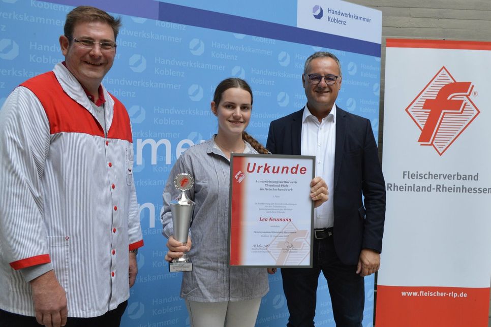 Landeslehrlingswart Manfred Schmitt (links) und Alexander Zeitler, Geschäftsführer des Fleischerverbandes Rheinland-Rheinhessen, gratulieren Lea Neumann, der besten Jung-Fleischerin in Rheinland-Pfalz.