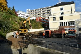 Um Platz für die neue Feuerwehrzufahrt zu machen, muss auch die alte Stützmauer verlegt werden. Der Erweiterungs-Neubau entsteht über dem Besucherparkplatz. Am 4.11. erfolgt dann der »offizielle« Spatenstich. Foto: Th. Wirtz