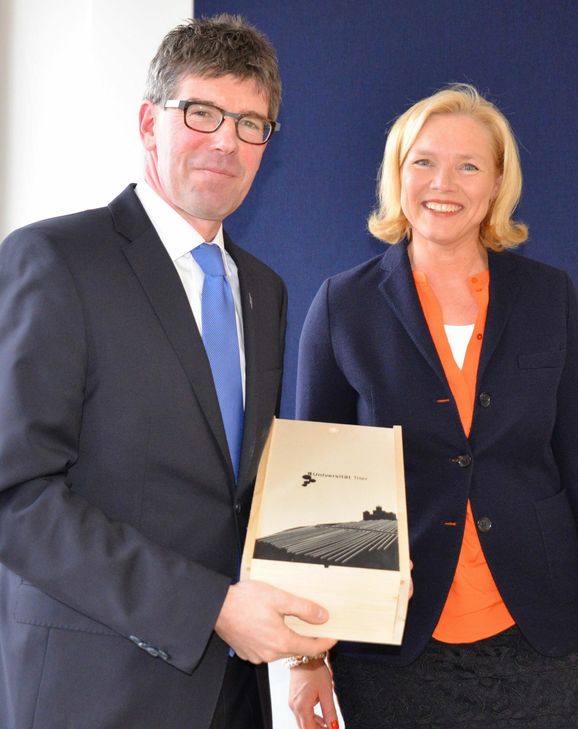 Universitätspräsident Prof. Dr. Michael Jäckel überreicht Prof. Dr. Ulrike Gehring eine Kiste mit Uni-Wein. Foto: Uni Trier