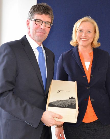 Universitätspräsident Prof. Dr. Michael Jäckel überreicht Prof. Dr. Ulrike Gehring eine Kiste mit Uni-Wein. Foto: Uni Trier
