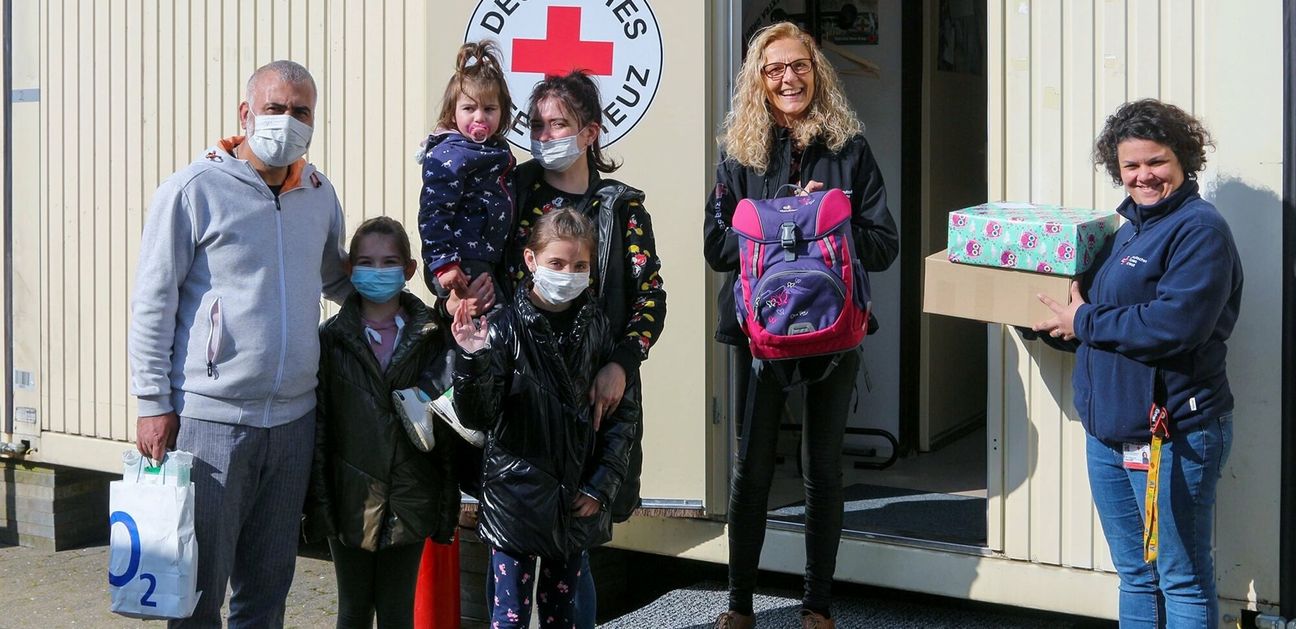 Sana Daghfous-Soussi, Mitarbeiterin im DRK-Beratungs- und Servicecenter Ahr, und DRK-Migrationsberaterin Maria Schön (v. re.) überreichten aus der DRK- Hilfsmittelausgabestelle einen Schulranzen an das ukrainische Mädchen Renata Matskiv (Mitte). Die Familie ist vor dem Krieg in der Ukraine geflüchtet und bei Verwandten in Sinzig untergekommen.