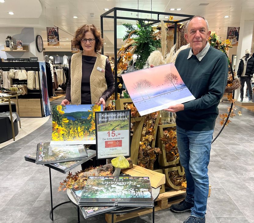 Peter Stollenwerk und Conny Bauer, Mitarbeiterin bei »Victor fashion« präsentieren den neuen Eifelkalender, der ab sofort im Imgenbroicher Modehaus erhältlich ist.