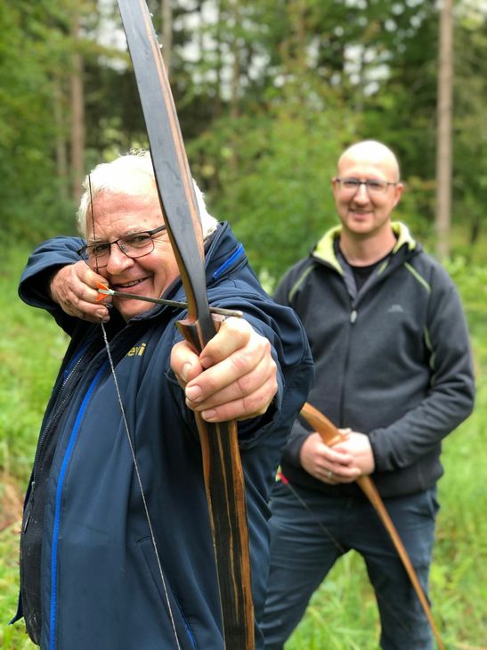 Devid Hörnchen macht es vor, Schleidens Bürgermeister Ingo Pfennings macht es nach: So wird auf den lebensgroßen Bison im Kammerwald gezielt. Foto: Breuer