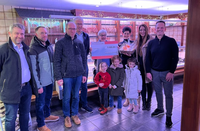 Vertreter des Gewerbevereins und der Metzgerei Titz gratulierten Elke Heeren (4.v.r.) zum Hauptpreis bei der Simmerather Weihnachtsverlosung.