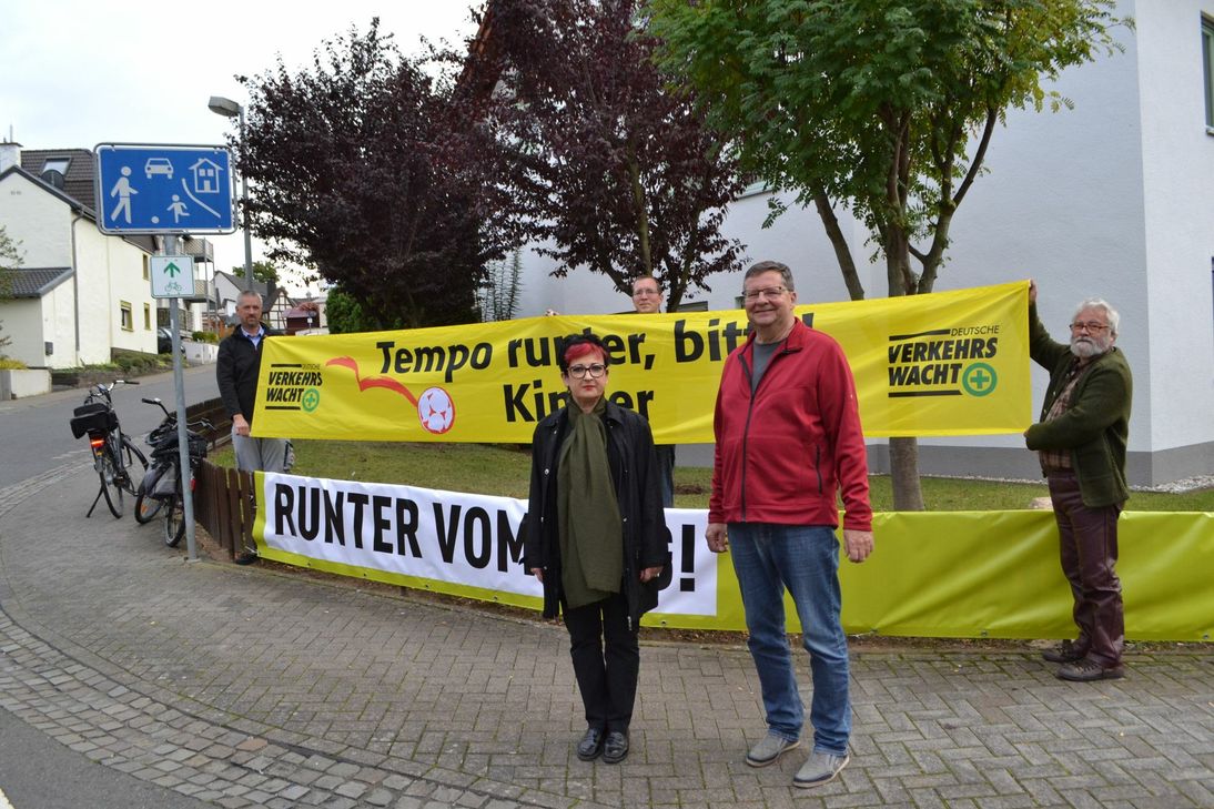 »Tempo runter, bitte! Kinder« und »Runter vom Gas!« mahnen die leuchtend gelben Banner, die Heinz Kurth (v.l.), Cornelia Brodeßer, Johannes Stieber, Ulrich Stieber und Bernd Walther in Bachem aufgehängt haben. Foto: Mager